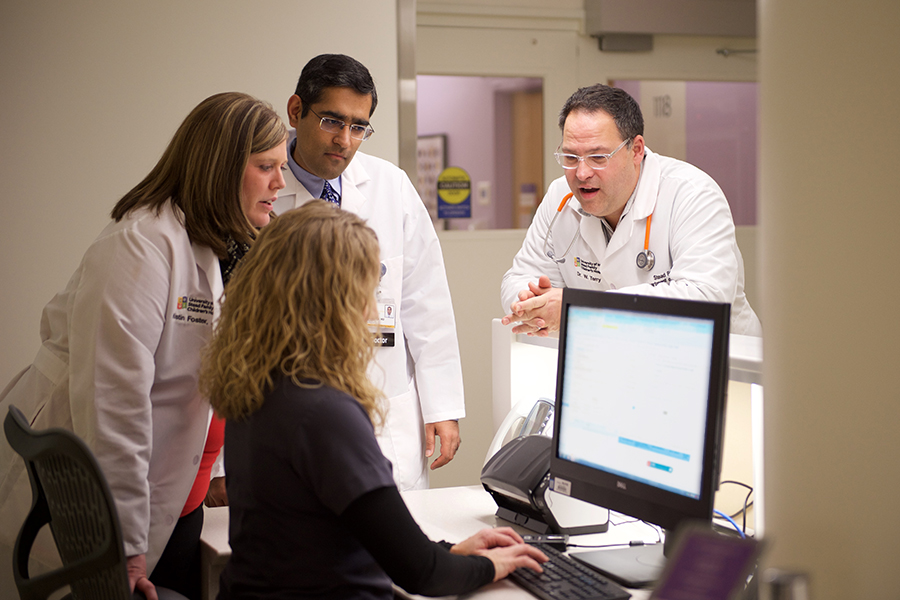 Doctors discussing around computer