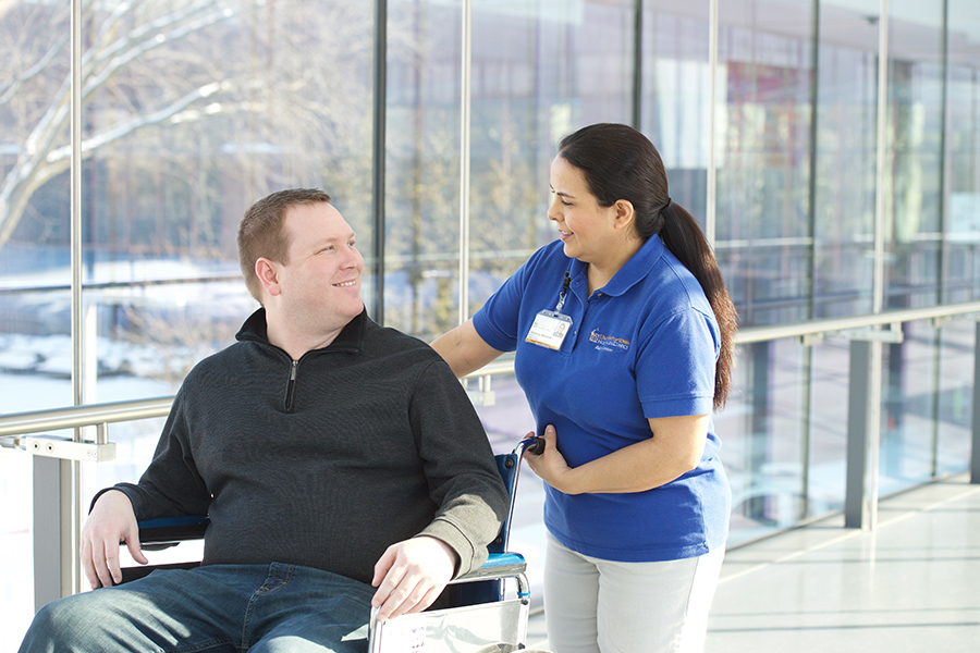 Patient transport team with patient in wheelchair